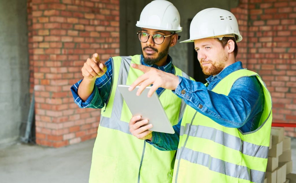 two construction professional workers pointing