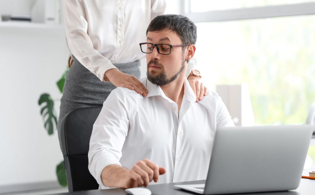 image of man being touched on shoulders by woman in office sexual harassment awareness training online course